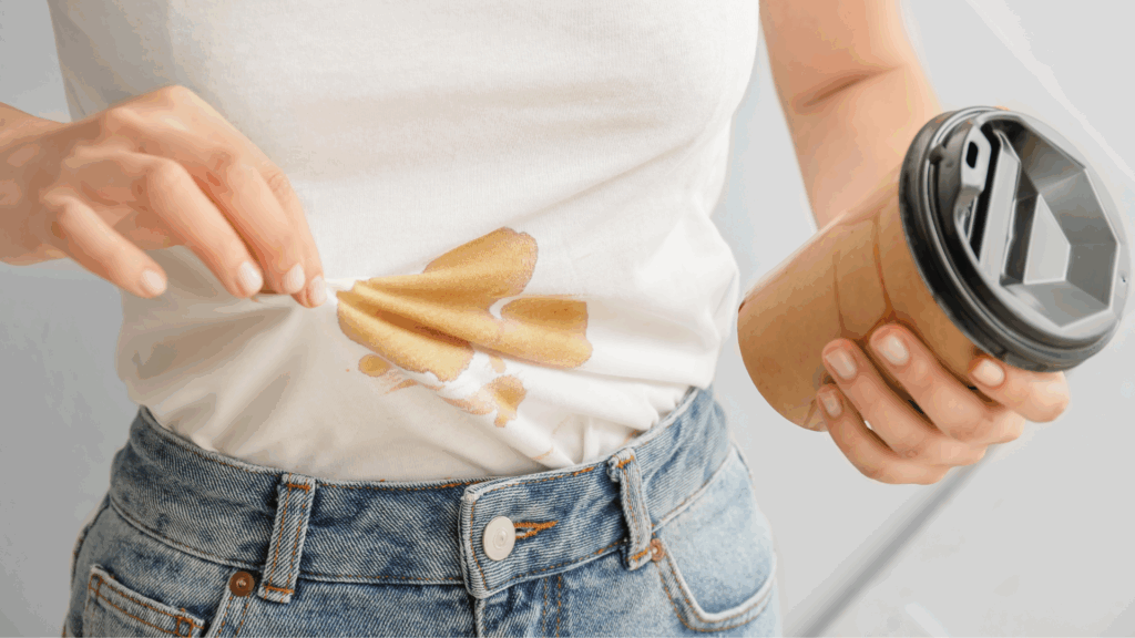 showcasing woman who spilled coffee on her white shirt and is now wondering how she can get it out